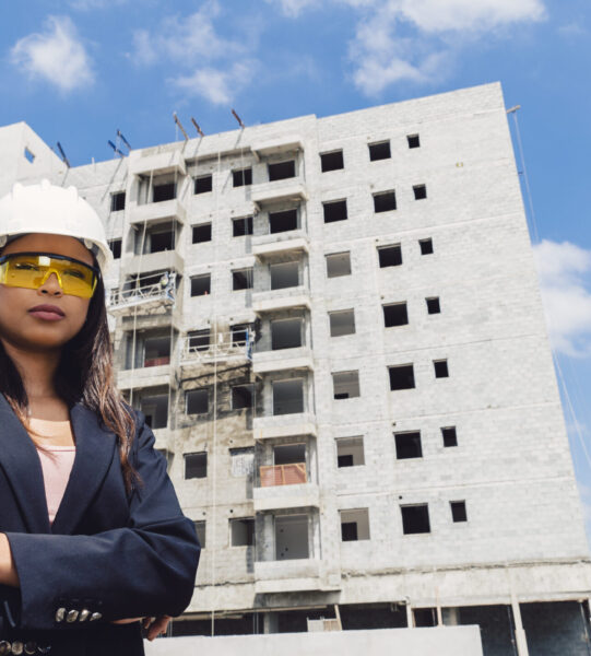 african-american-lady-safety-helmet-eyeglasses-near-building-construction