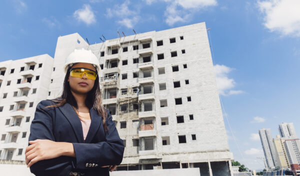 african-american-lady-safety-helmet-eyeglasses-near-building-construction